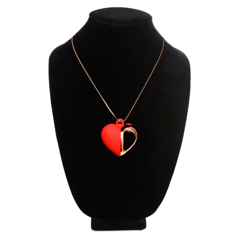 Red and rose gold heart pendant necklace on a black display.