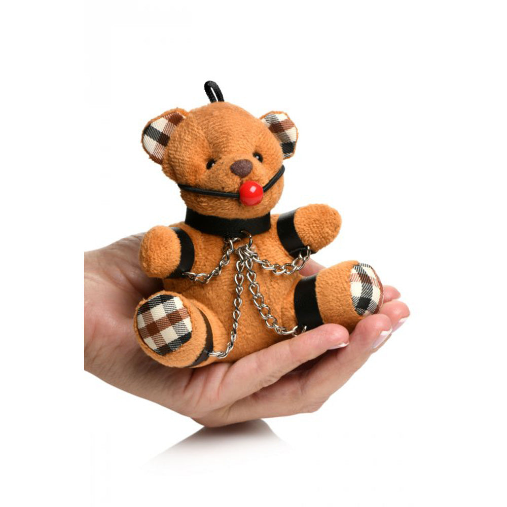 Burnt orange teddy bear keychain with bondage accessories.