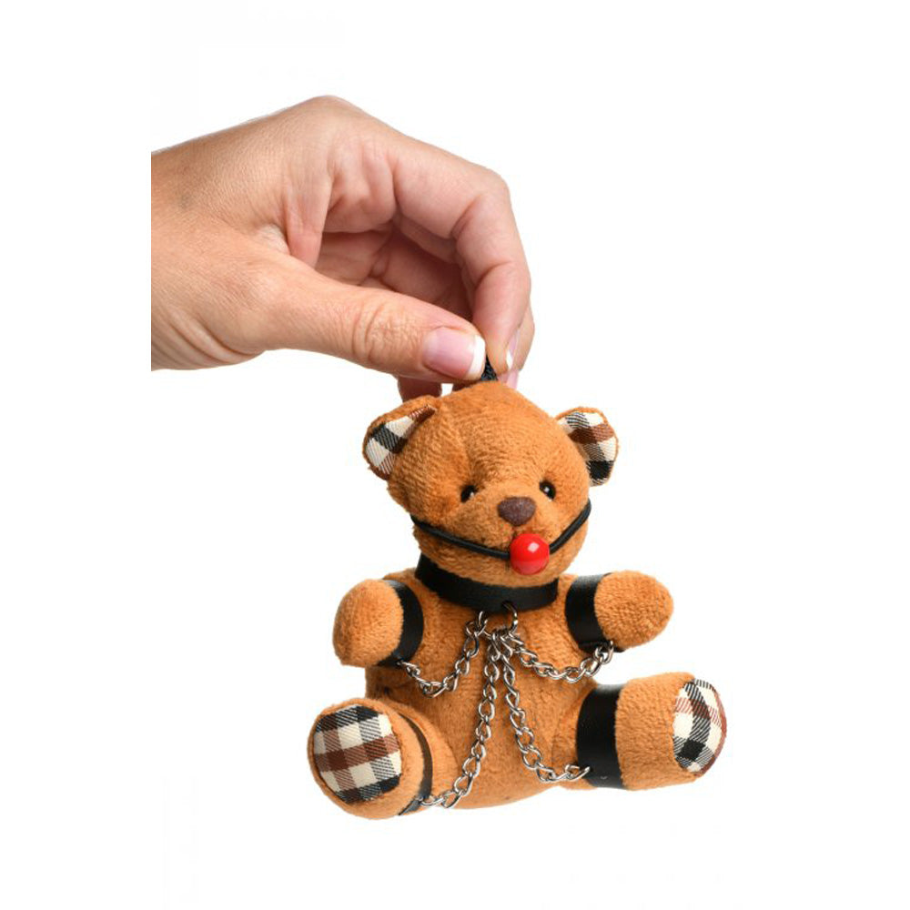 Burnt orange teddy bear keychain with ball gag and chains.