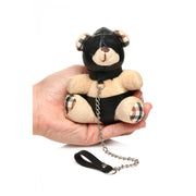 A teddy bear keychain with a black hood and leash.