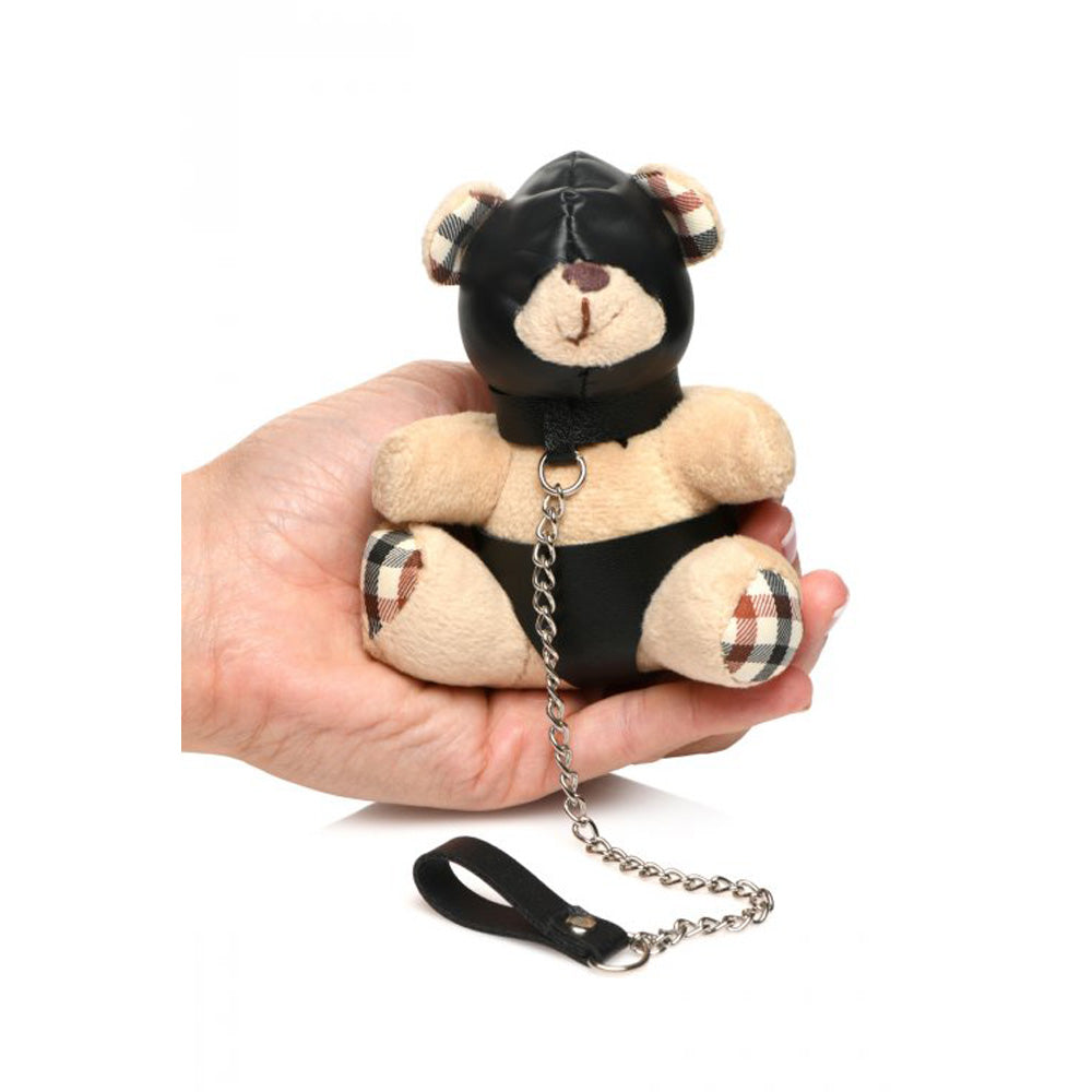 A teddy bear keychain with a black hood and leash.