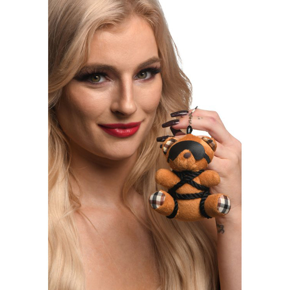 Burnt orange teddy bear keychain with Shibari-style rope and blindfold.