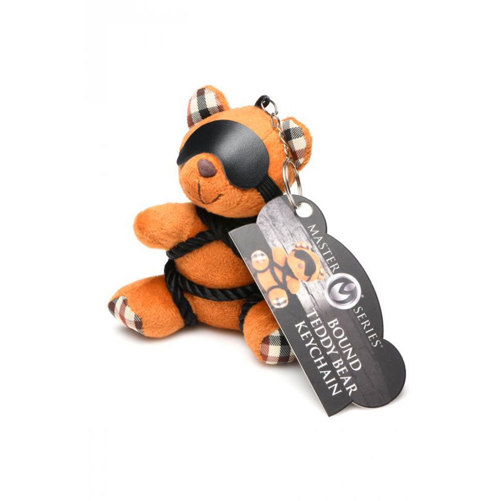 Burnt orange teddy bear keychain with black blindfold and rope details.