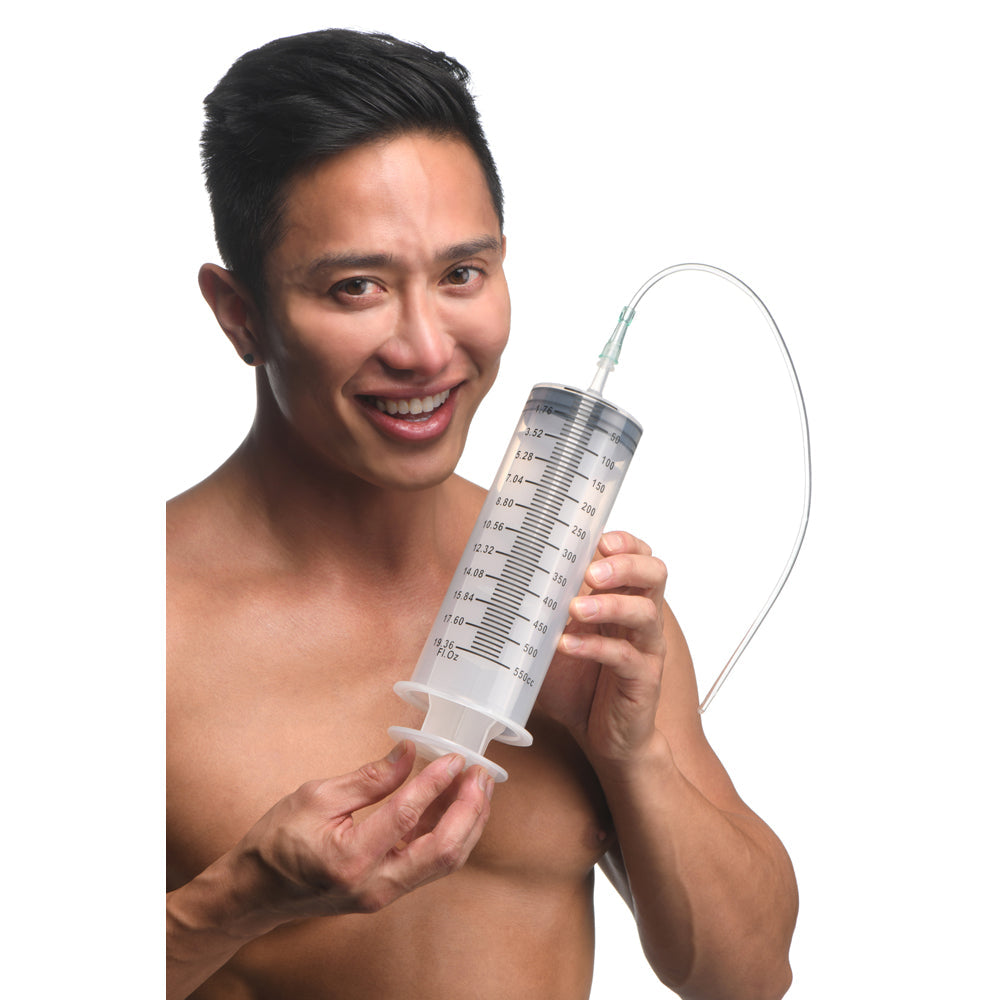 A man holds a large 550ml clear syringe with measurement markings and a silicone tube.