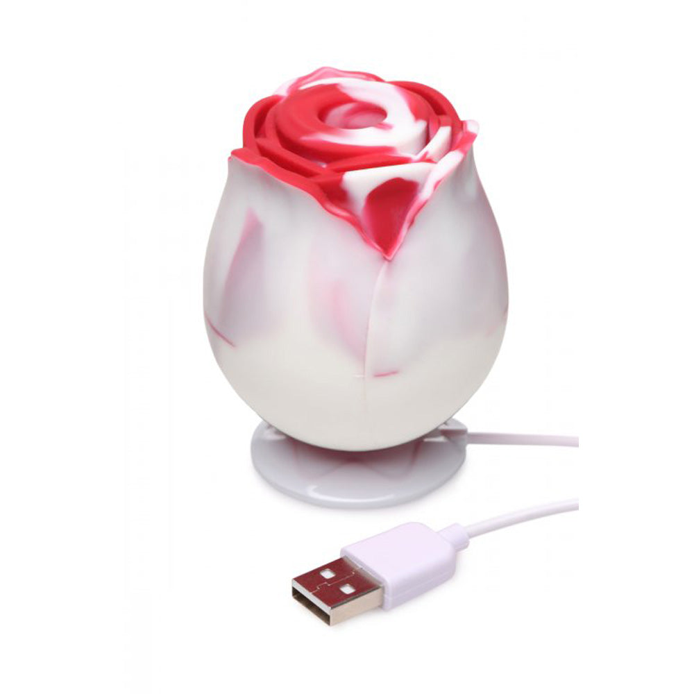 A white and red silicone rose toy with a USB cable.