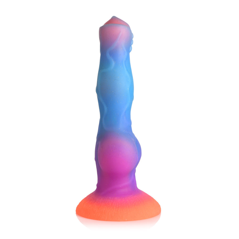 A glow-in-the-dark silicone dildo with a suction cup base in orange, purple, and blue.