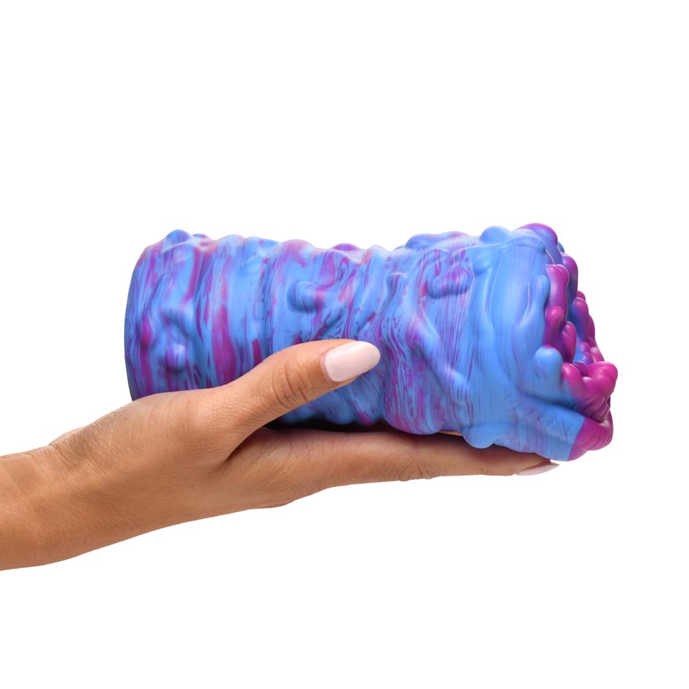 A blue and pink textured silicone stroker held in a hand.