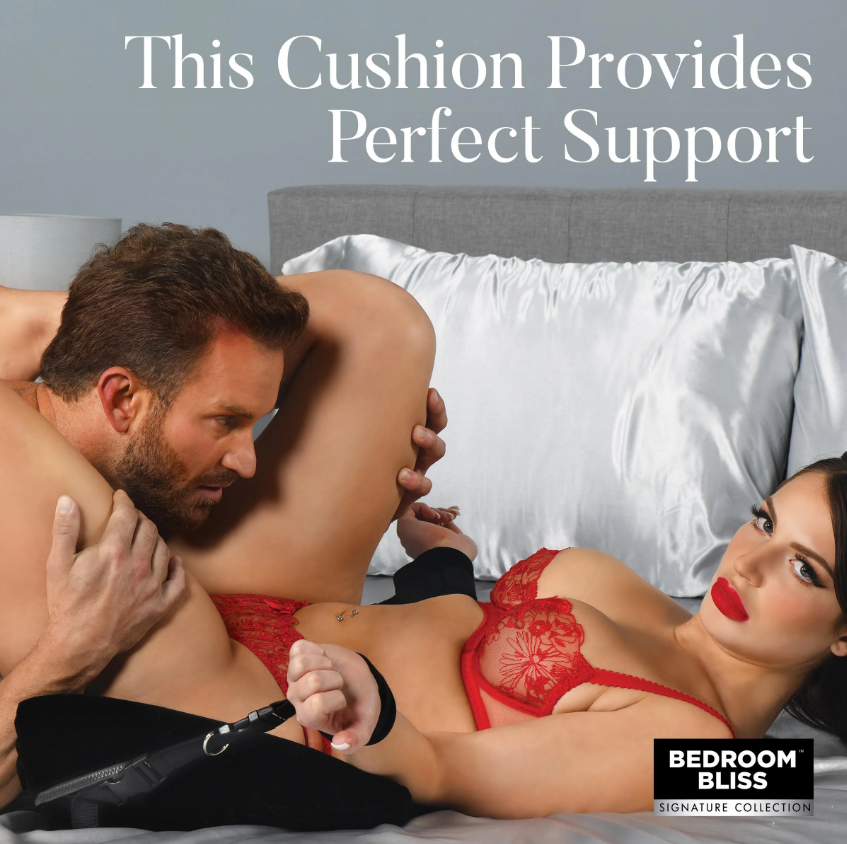 A black velvet bondage wedge pillow with restraint cuffs.