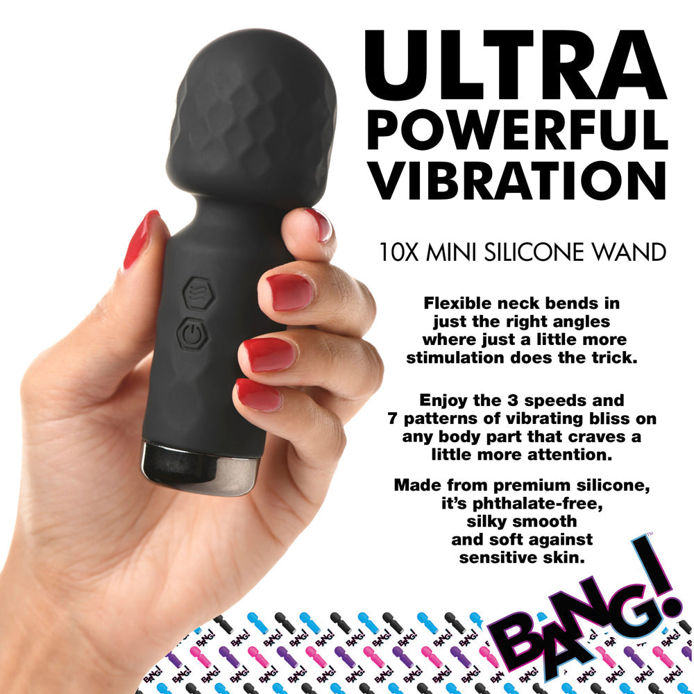 A black mini silicone wand vibrator held in a hand with red nail polish.