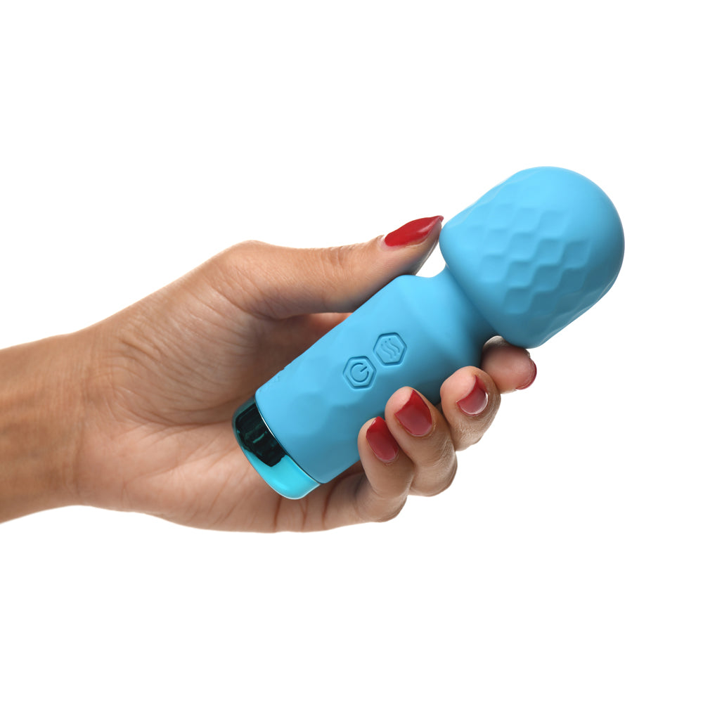 A hand holds a small, blue silicone wand vibrator with textured and button details.
