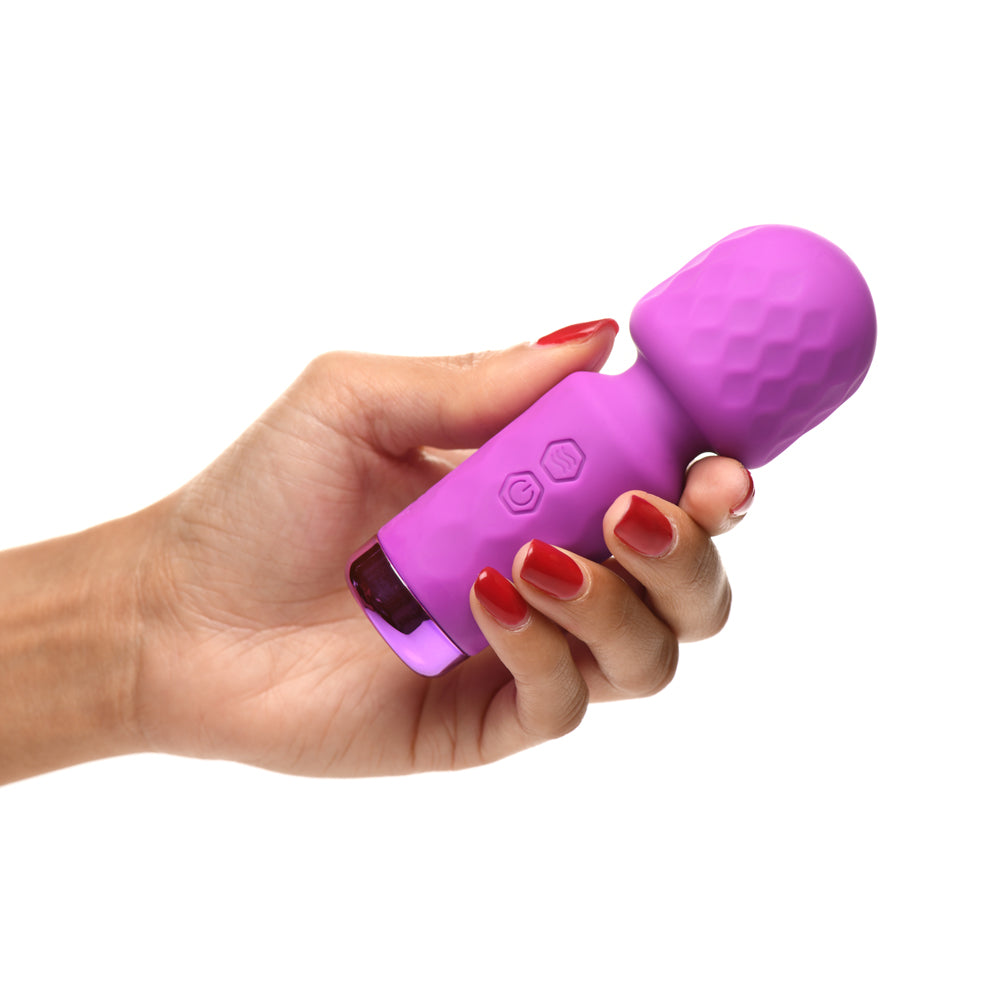A purple silicone wand vibrator with textured head and control buttons held in a hand.