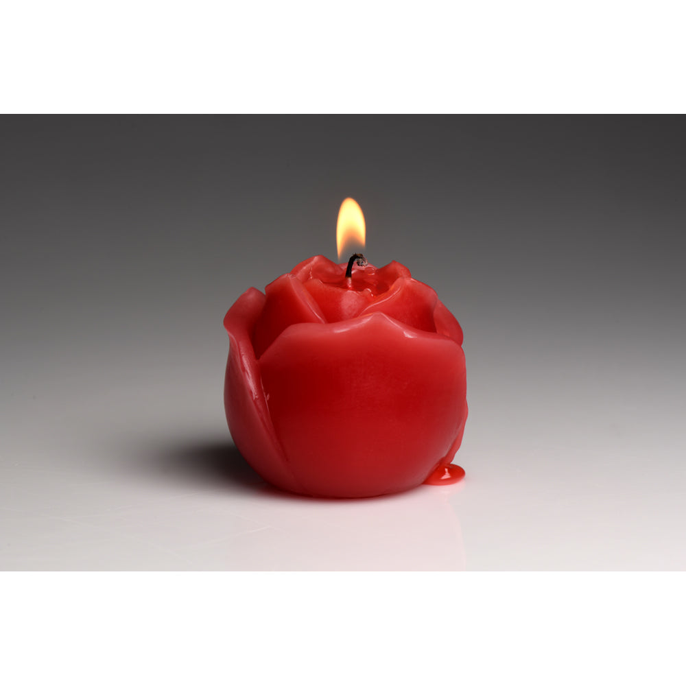 Red rose-shaped candle with a lit wick and dripping wax.