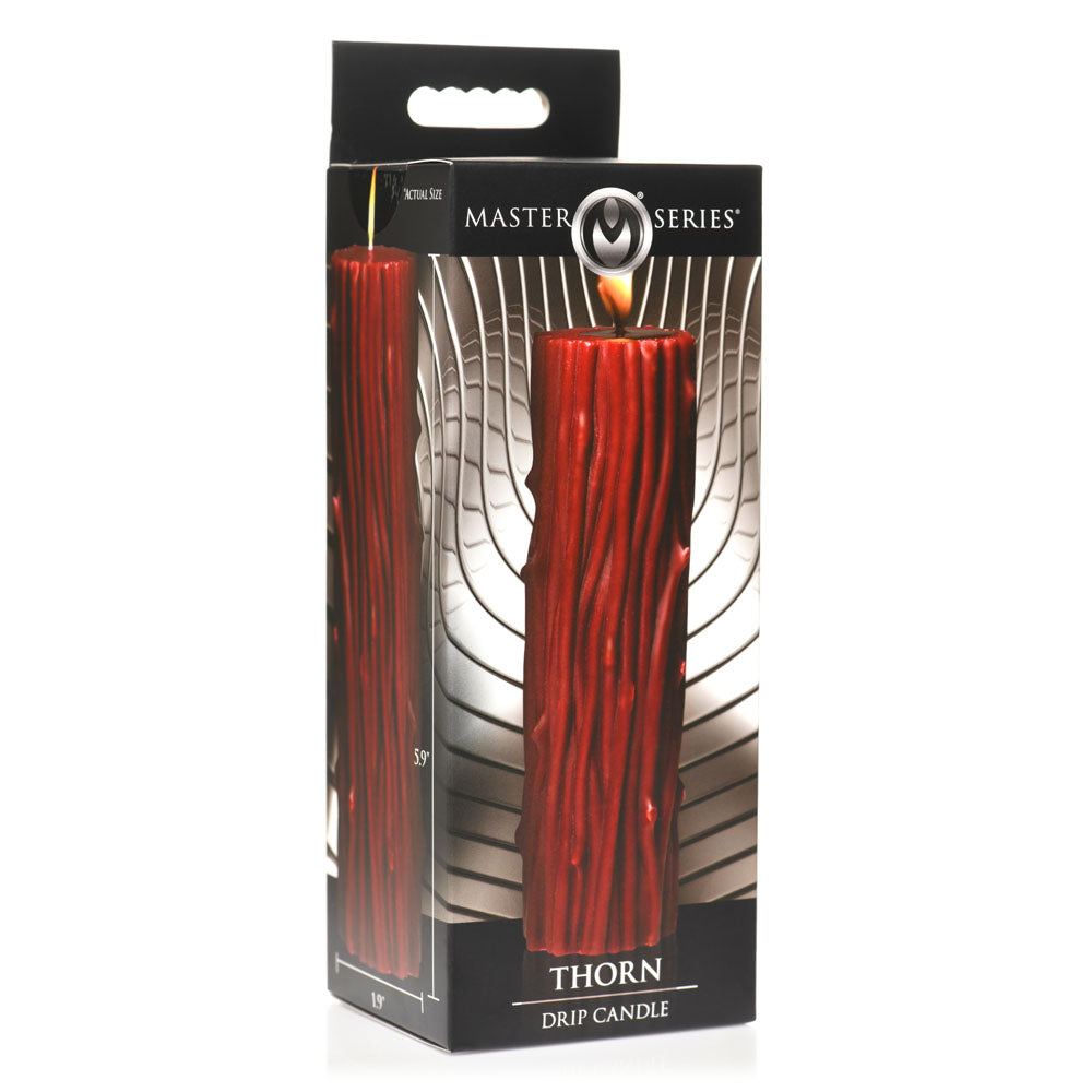 A red Thorn Pillar Drip Candle in its packaging.