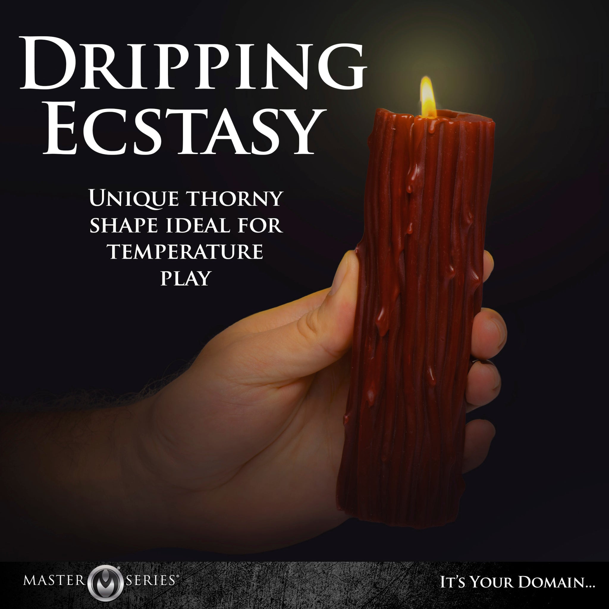 A red thorn pillar drip candle held in a hand.