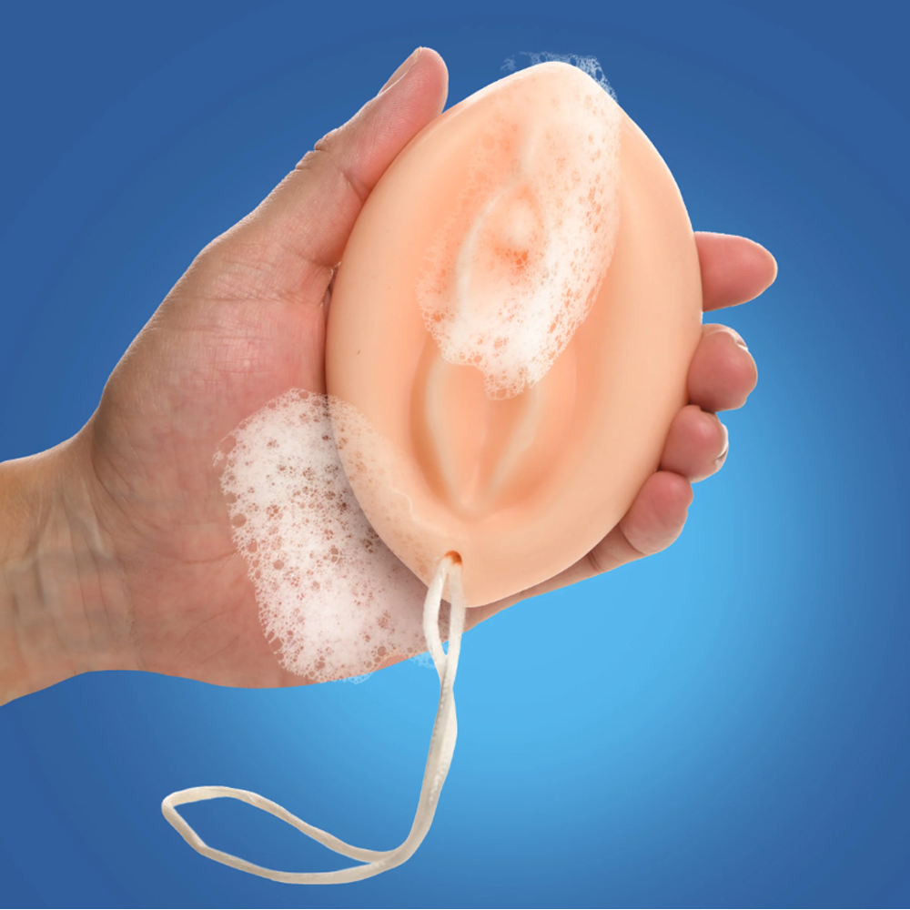 Peach-colored vulva-shaped soap on a rope with lather.
