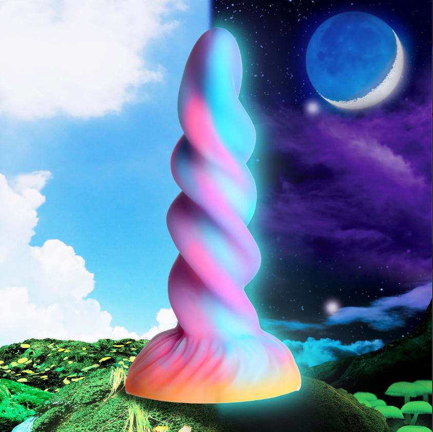 A rainbow-colored spiral dildo with a glowing base sits on a fantasy landscape.