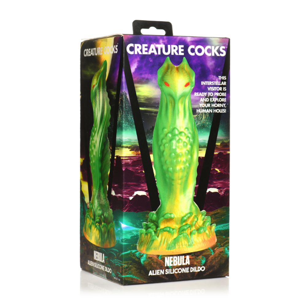 Green and yellow alien-shaped silicone dildo with red eyes on a box.