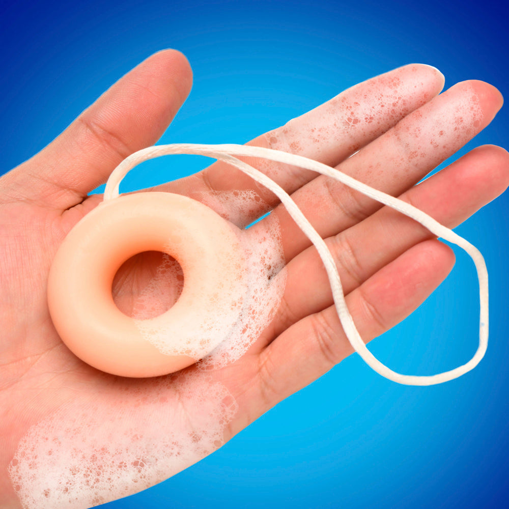 C-ring shaped soap on a rope with lather in a hand.