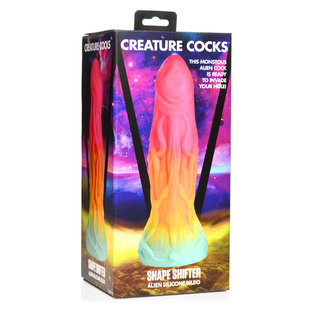 A rainbow-colored alien-shaped silicone dildo with tentacles on a box.