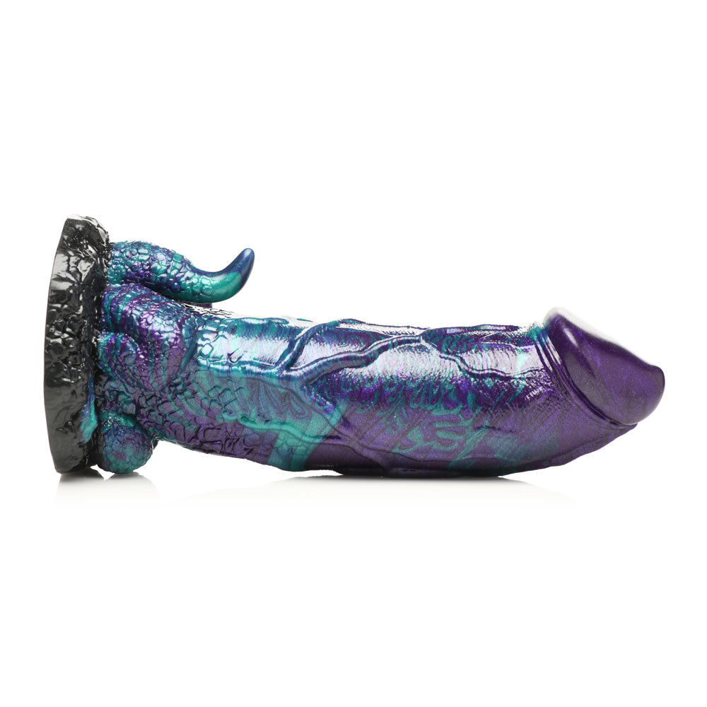A purple and teal dinosaur-shaped silicone dildo with a suction base.