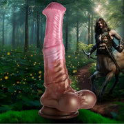 Pink silicone centaur fantasy dildo with suction cup base in forest scene.