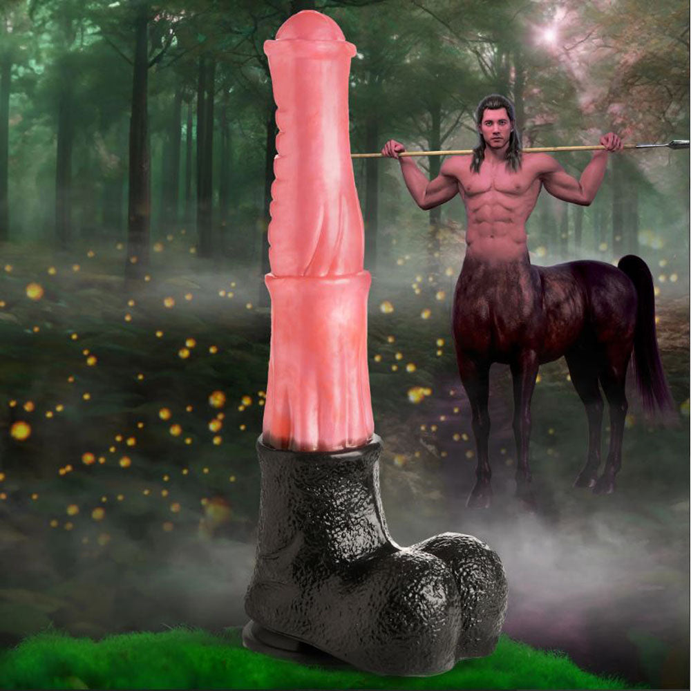 Giant centaur silicone dildo with suction cup base in a forest setting.