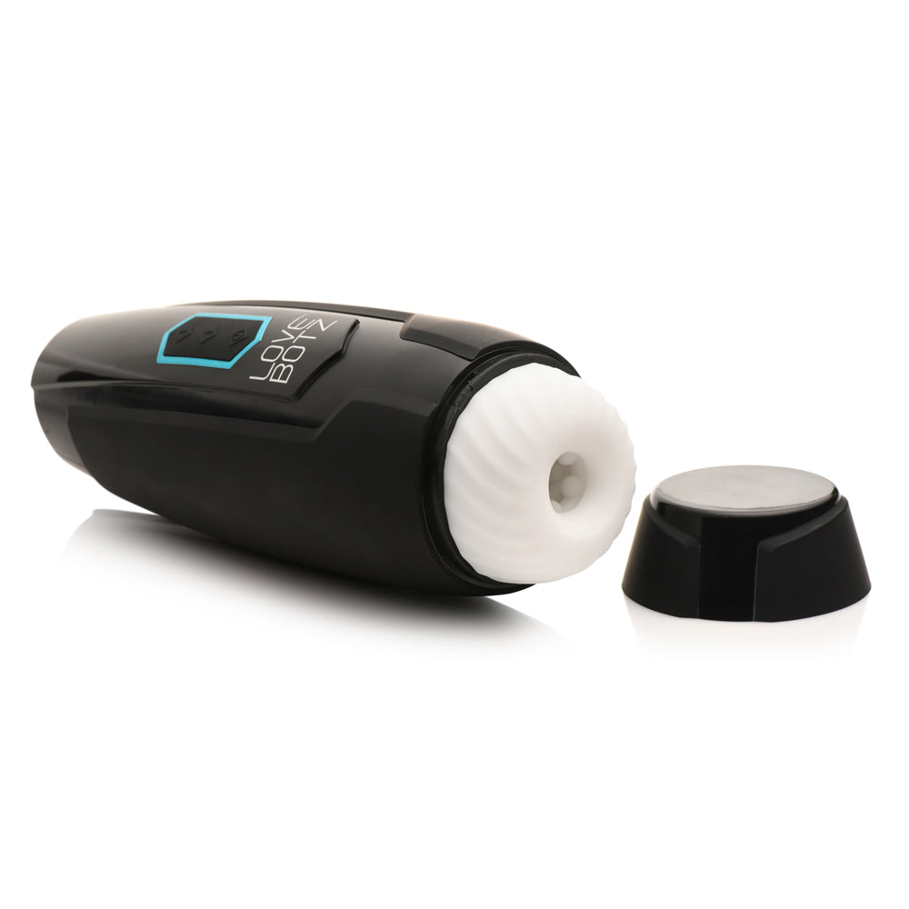 Black rechargeable masturbator with white textured insert and detached cap.