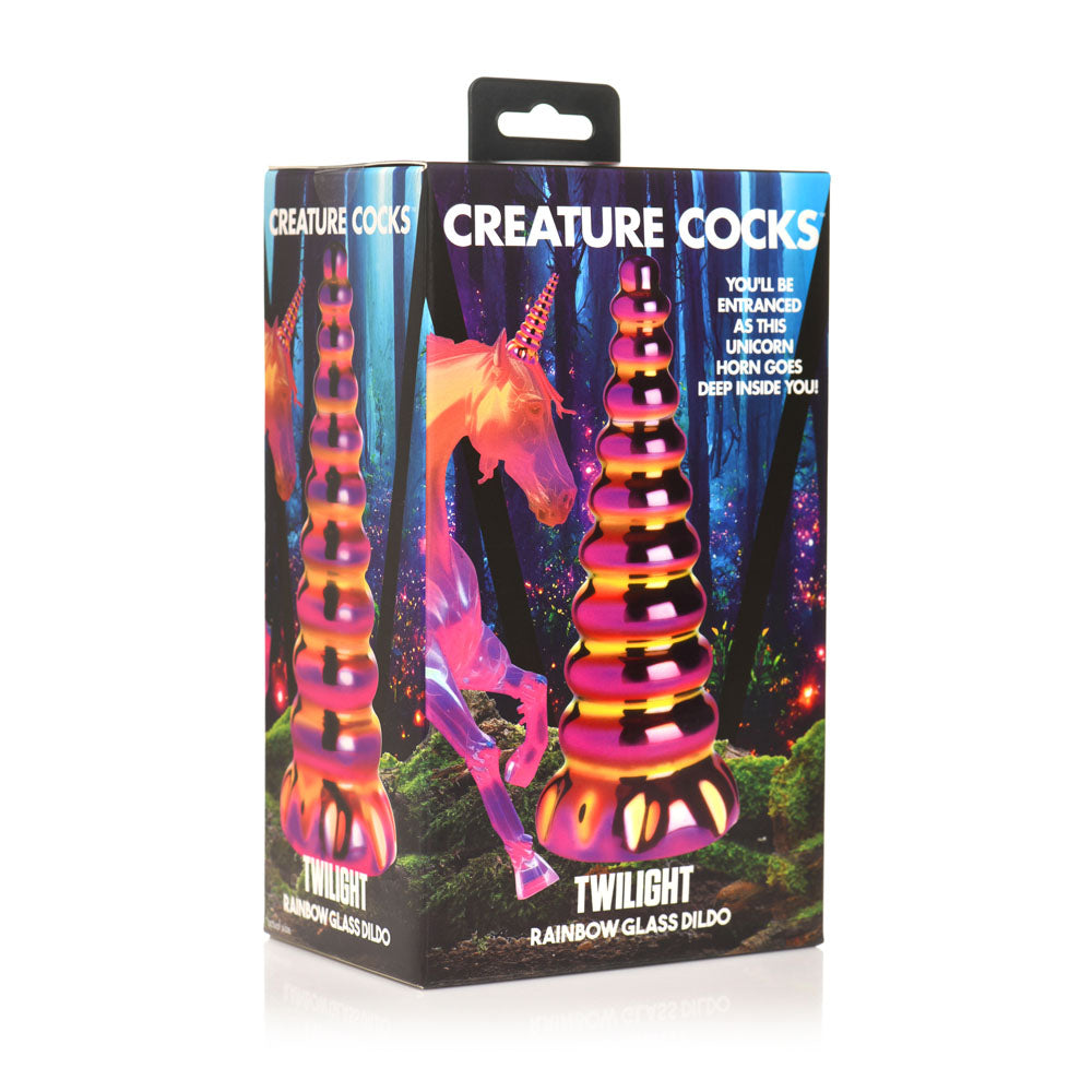 A rainbow glass dildo shaped like a unicorn horn on a box.