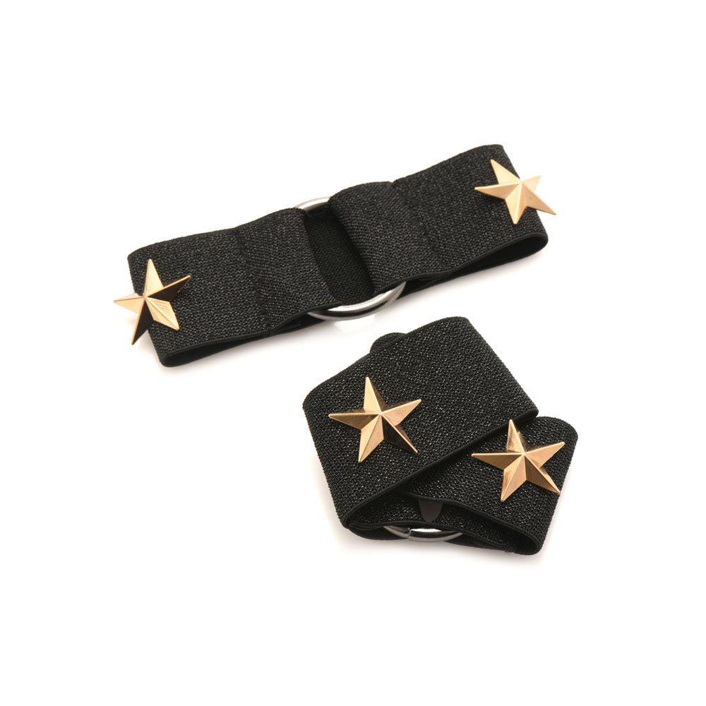 Black chest harness and arm bands set with gold stars.