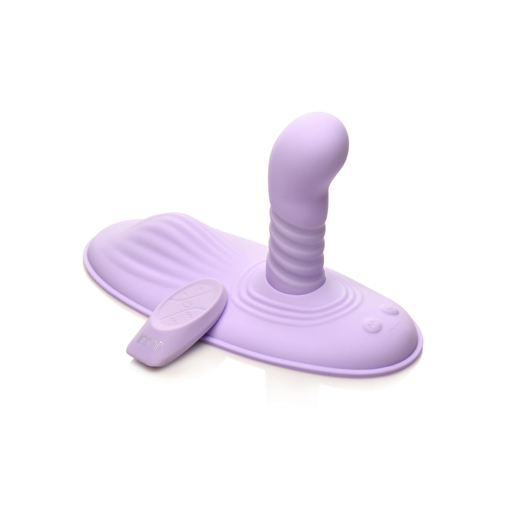 A purple silicone grinding pad with a ribbed stimulator and remote control.