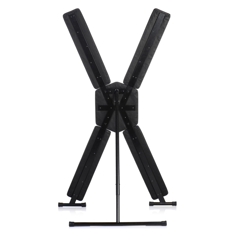 A black St. Andrew's cross with padded restraints and a metal stand.