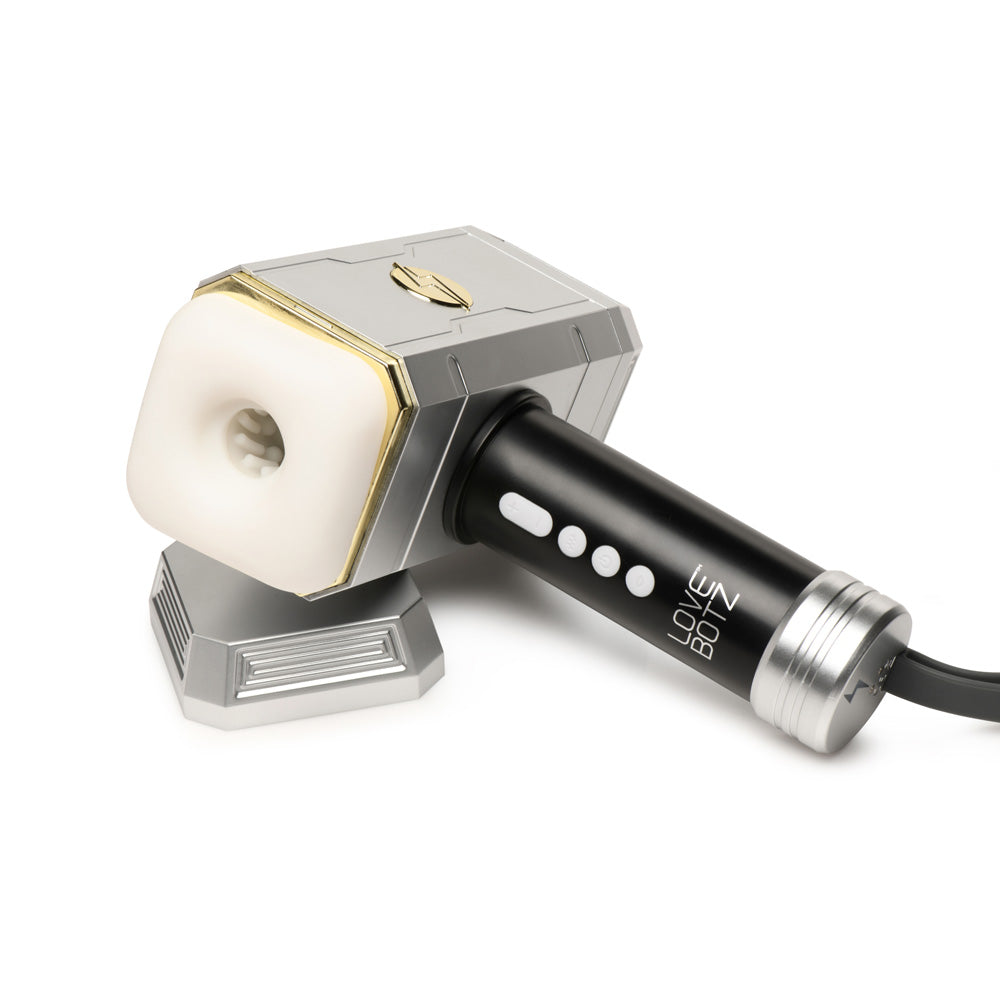 A silver and gold hammer-shaped vibrator with a white textured sleeve.