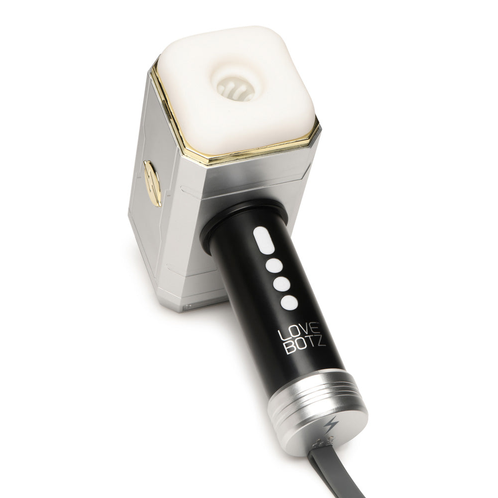 Rechargeable vibrating and sucking hammer toy with a silver body and black handle.