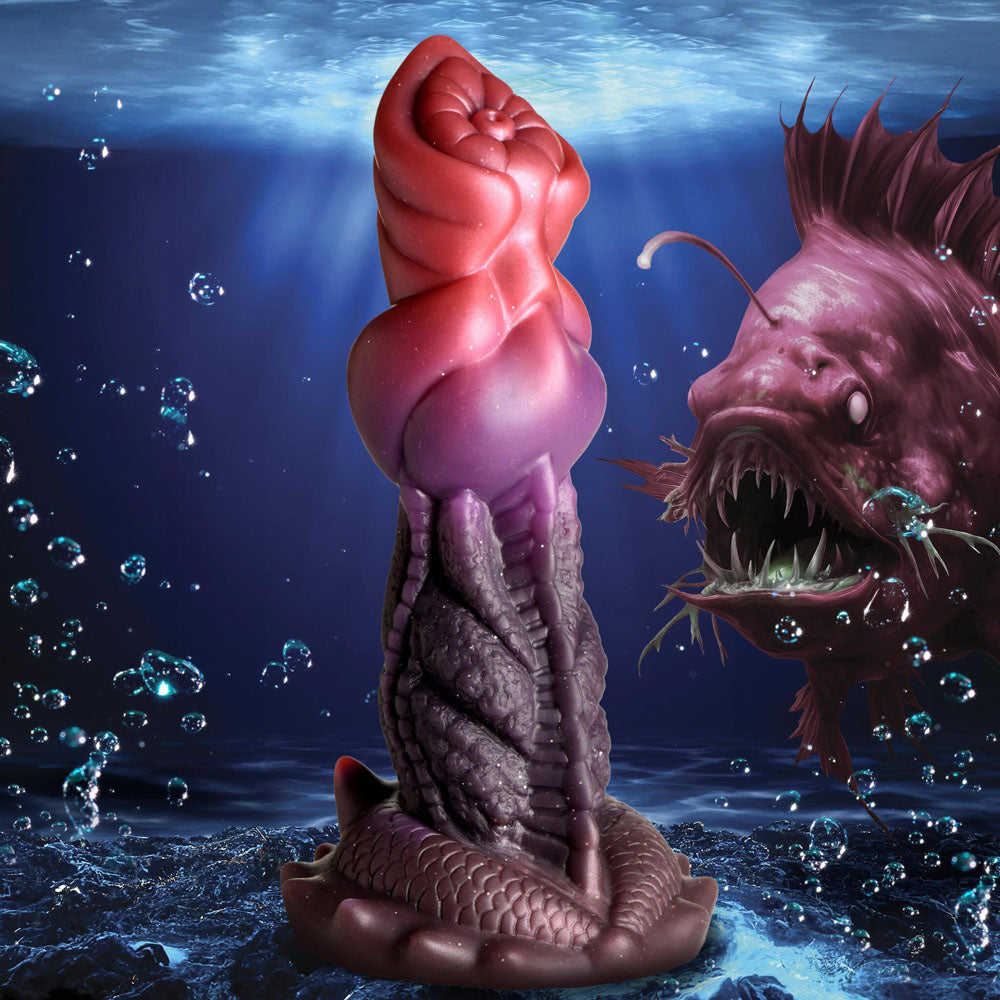 A purple and red silicone dildo with a ribbed shaft and suction cup base, next to a monstrous fish.