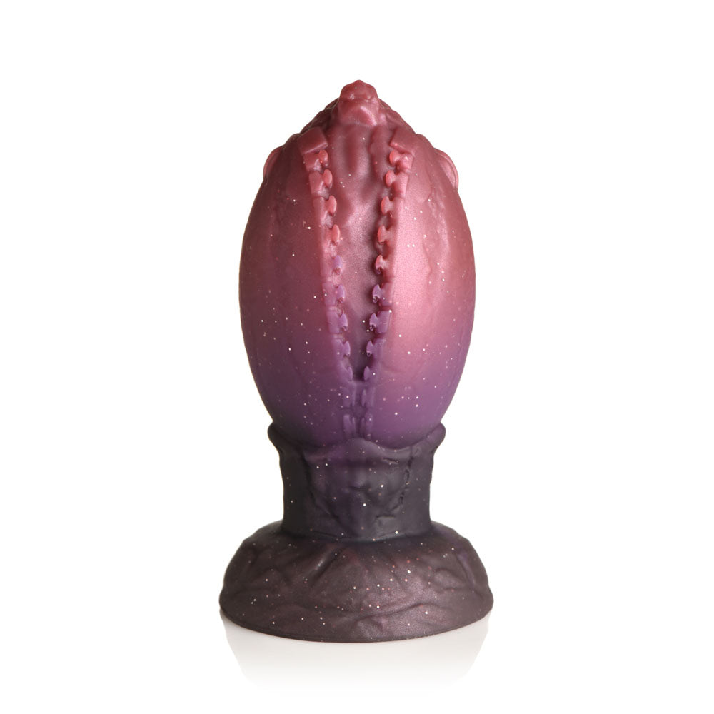 A large, glittery red and purple egg-shaped plug with textured ridges and a wide base.