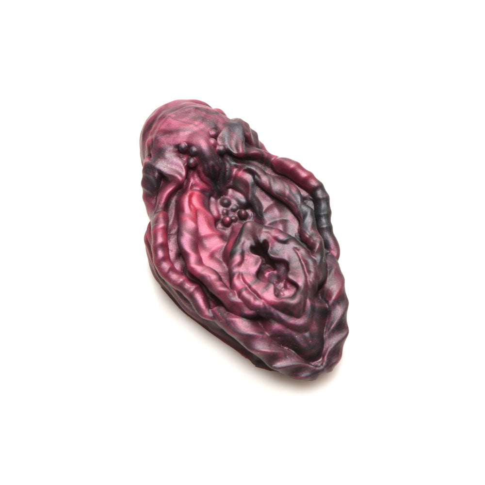 Textured red and black silicone vulva grinder with alien-inspired design.