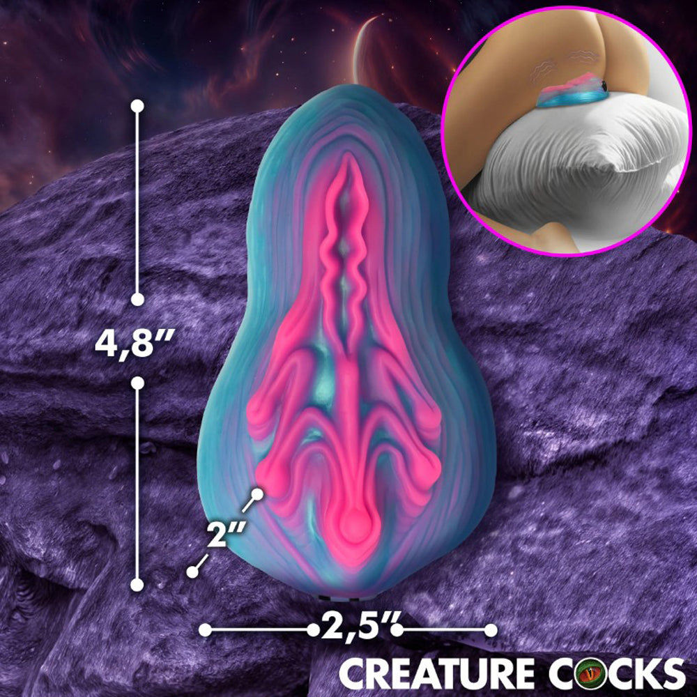A blue and pink silicone vulva toy with dimensions indicated.