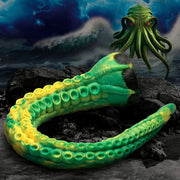 Green and yellow silicone tentacle dildo with suckers on a rocky shore.