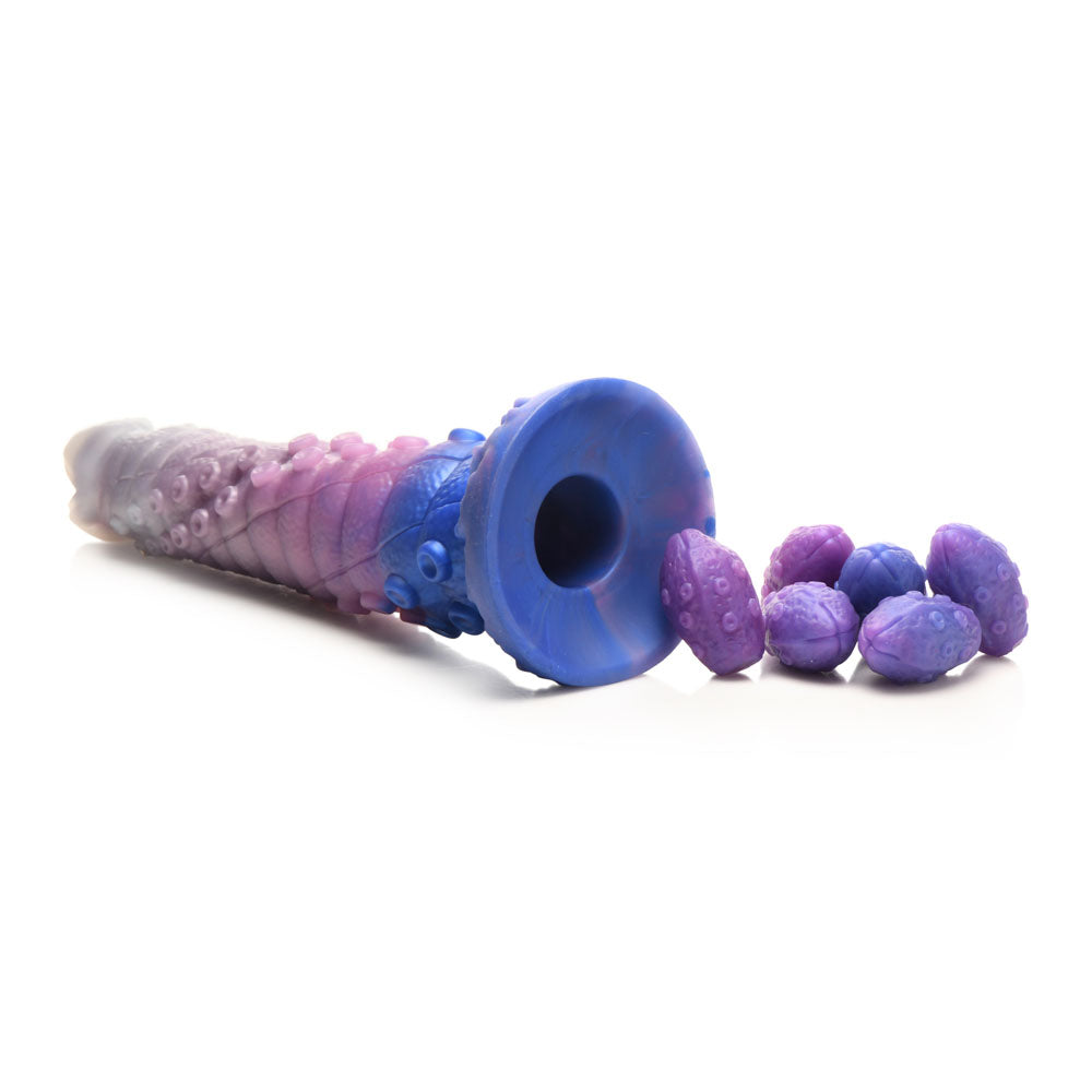 A large, blue and pink tentacle dildo with a flared base and a pile of purple eggs.