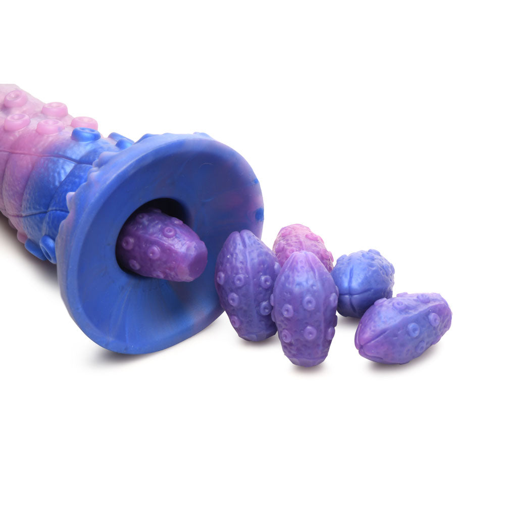 A purple and blue silicone ovipositor dildo with six textured eggs.