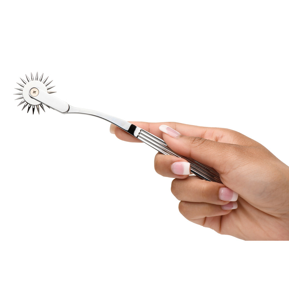 Stainless steel Wartenberg pinwheel sensation toy held in a hand.