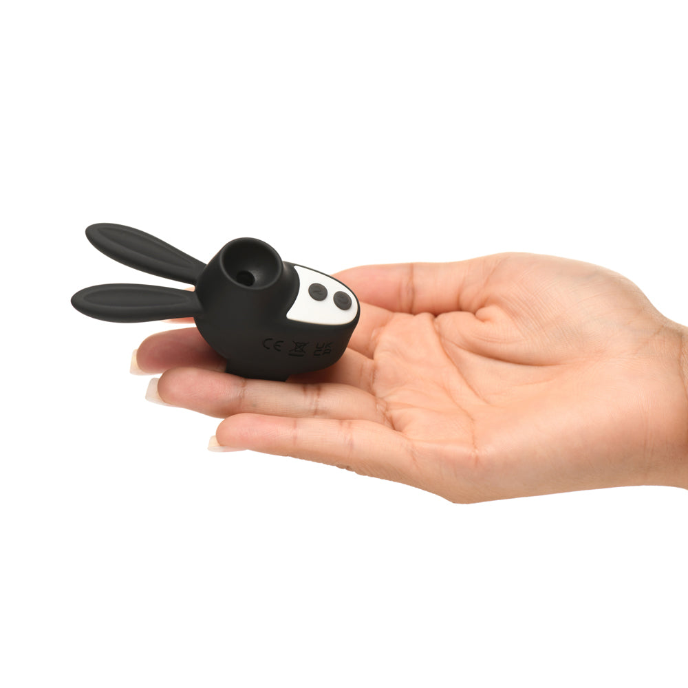 Black silicone bunny-shaped clitoral stimulator with two ears and two white dots.