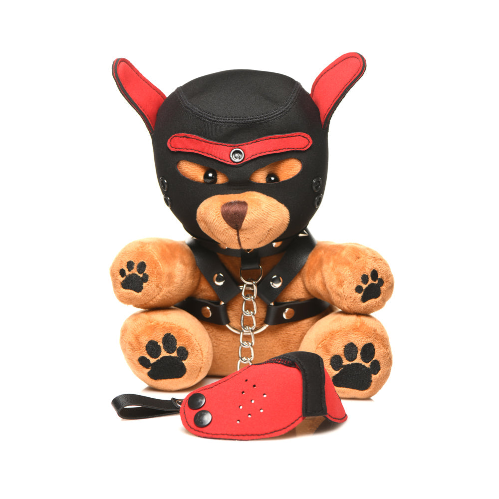 A plush teddy bear wearing a black and red dog-themed hood and harness.
