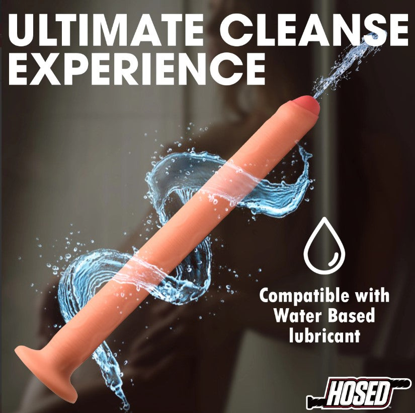 A long, thick, peach-colored silicone enema hose attachment with water splashing around it.