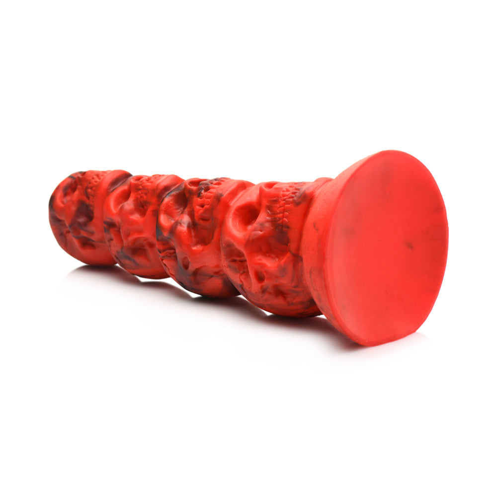 Red silicone dildo with a tower of skulls and a suction cup base.