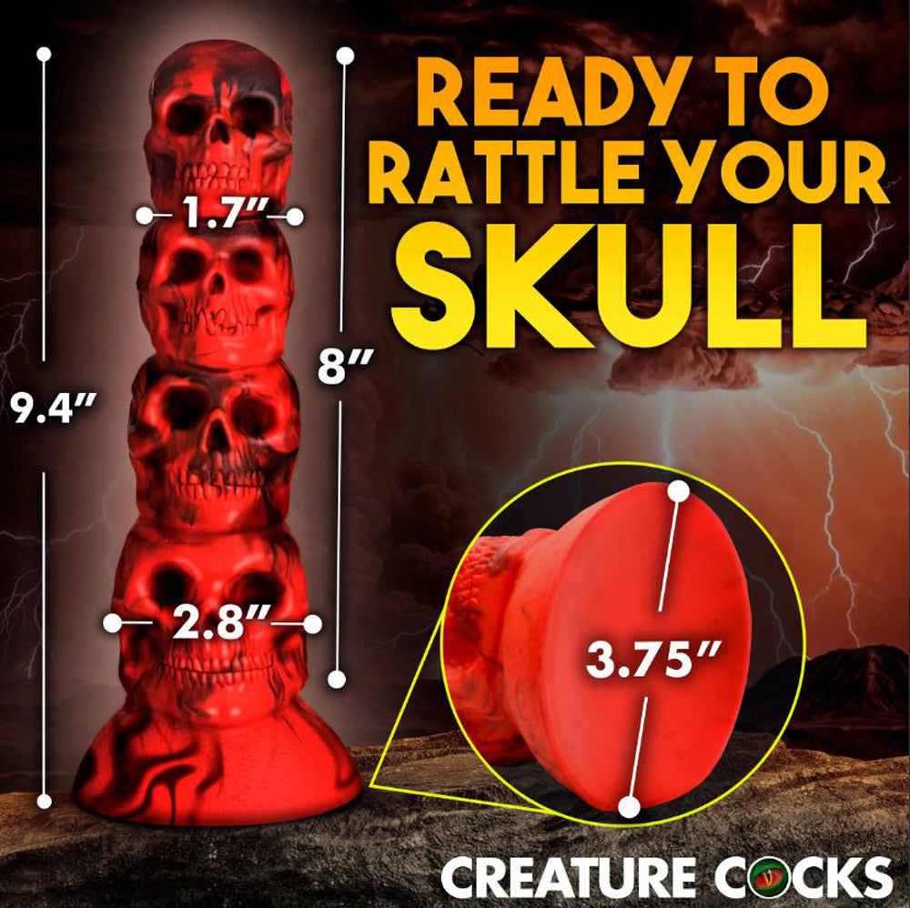 A red silicone dildo shaped like a tower of four skulls with a suction cup base.