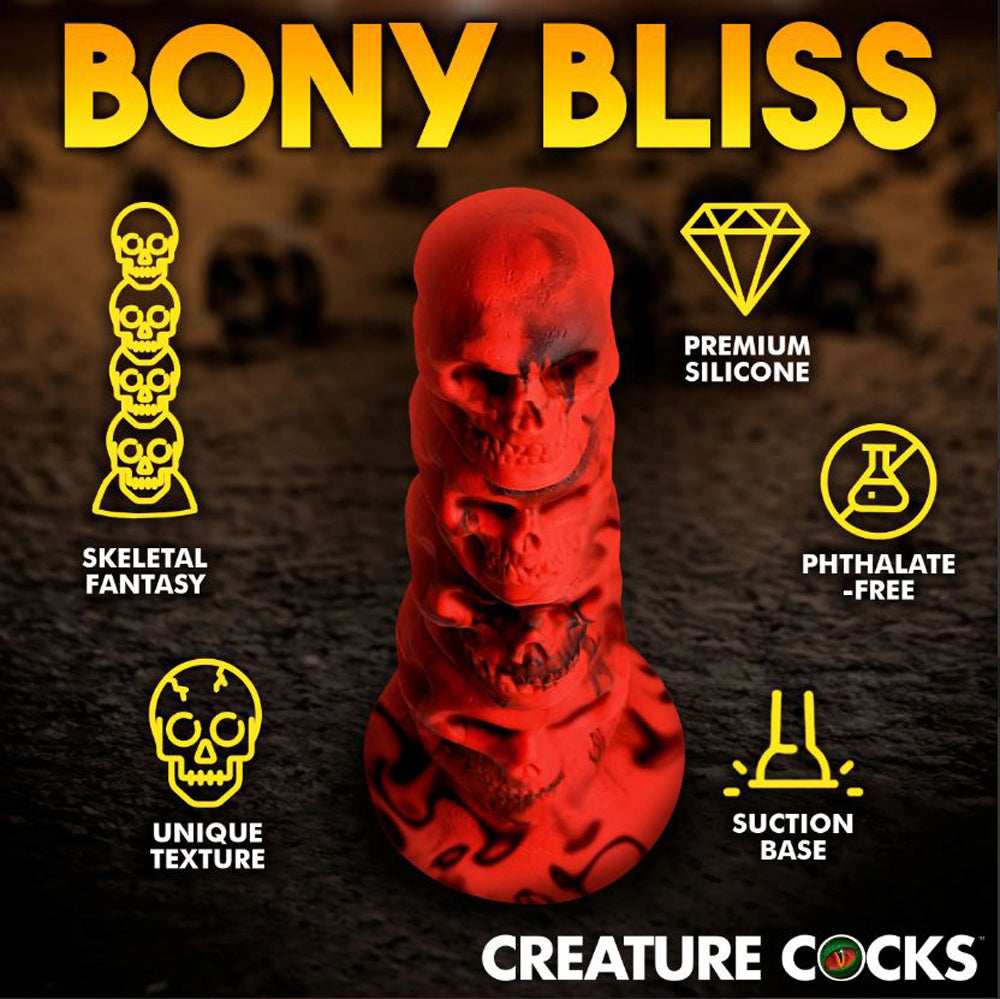 Red silicone dildo shaped like a tower of skulls with a suction base.