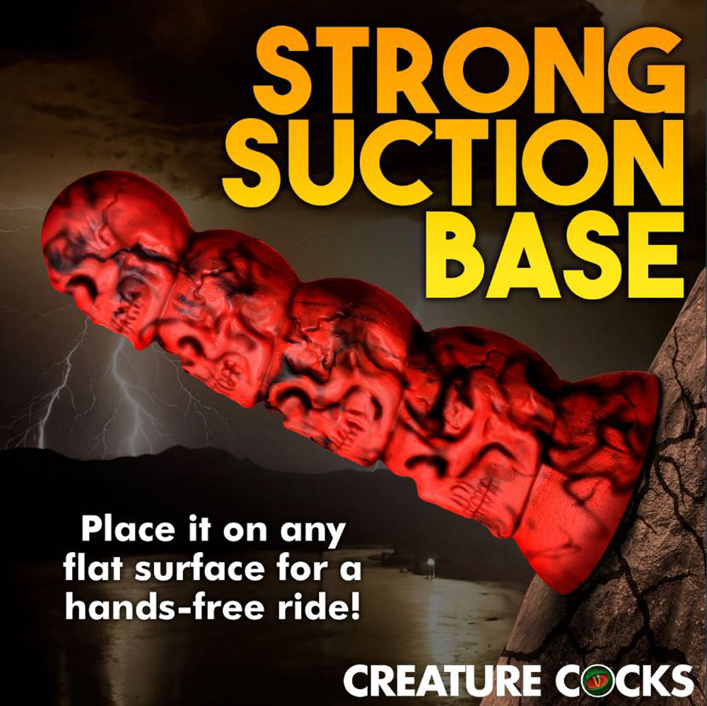 Red silicone dildo with four stacked skulls and a suction cup base.