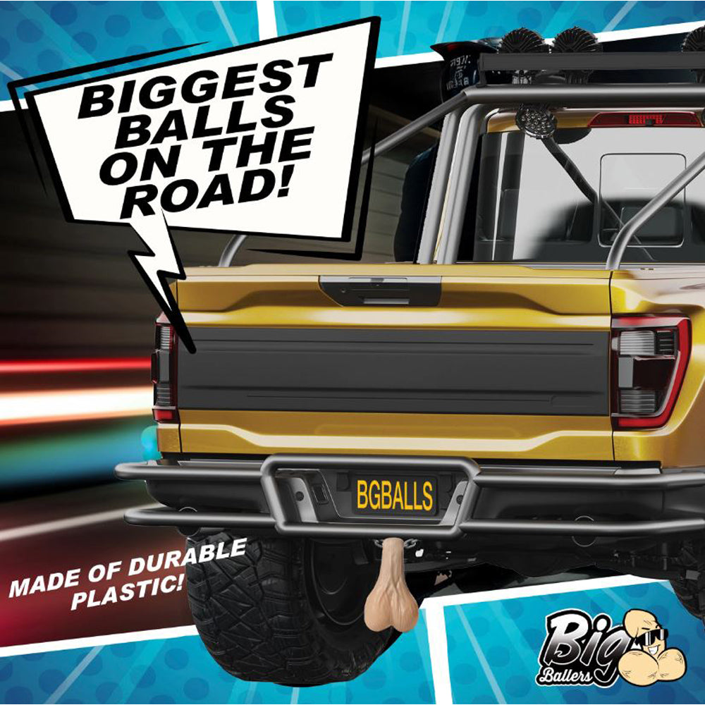 Yellow truck with large plastic testicles hanging from the hitch.