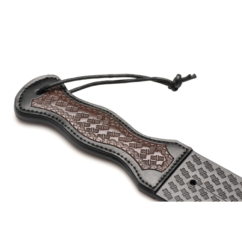 Black and brown vegan leather Scottish tawse with a patterned handle and a hanging loop.